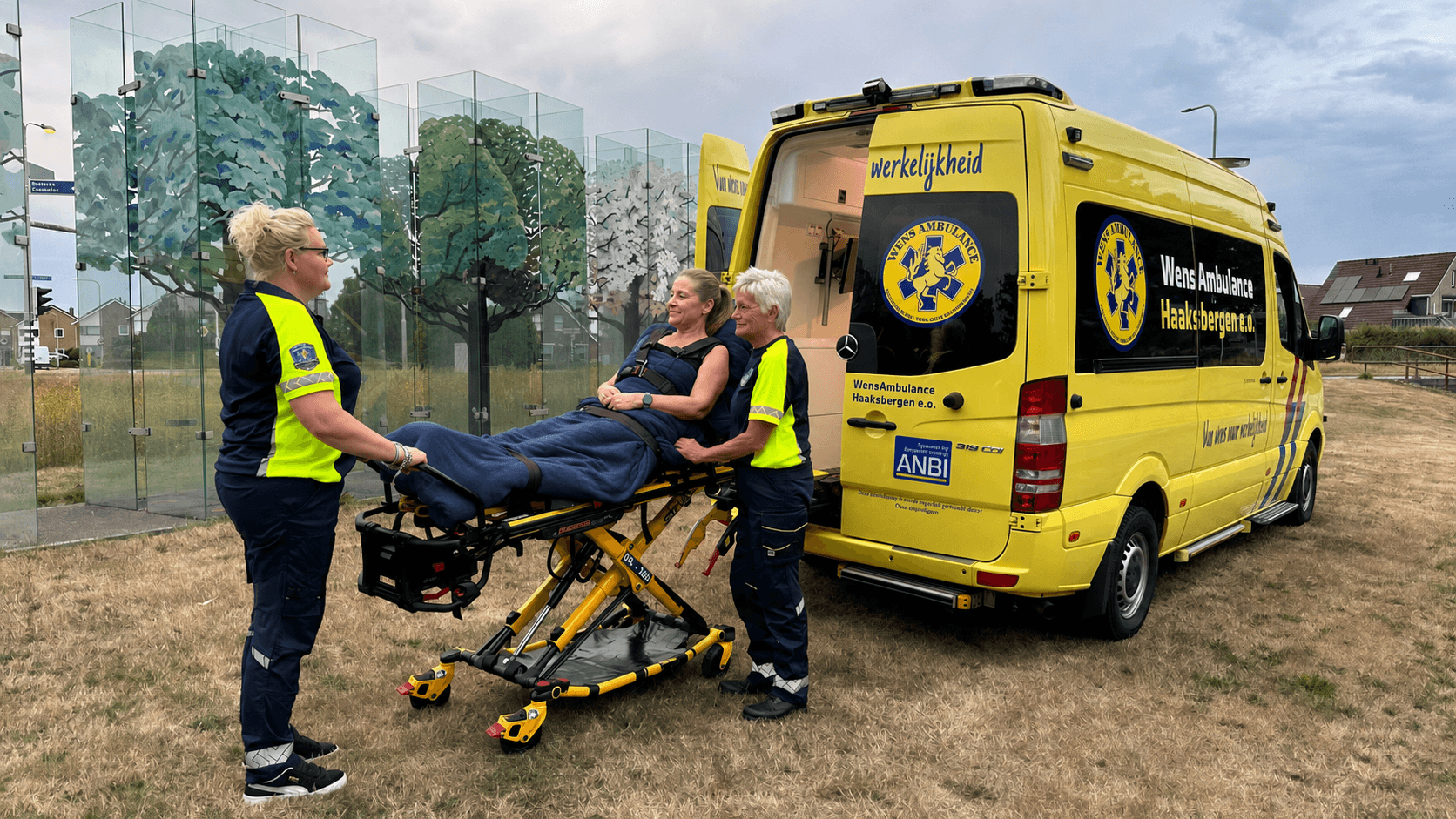 Vrijwilligers staan naast de WensAmbulance buiten