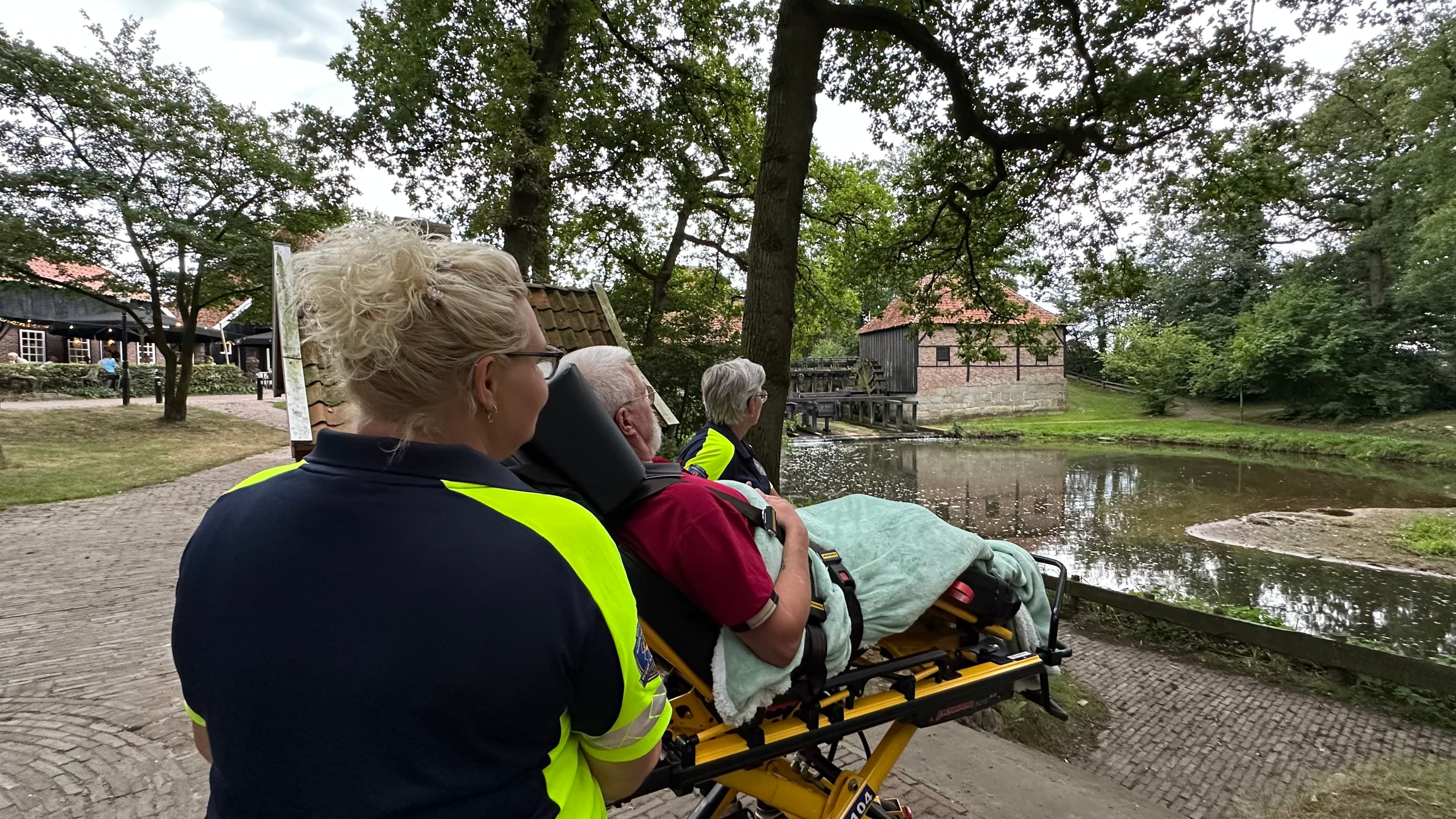 Vrijwilligers begeleiden een gast tijdens een wandeling langs de watermolen